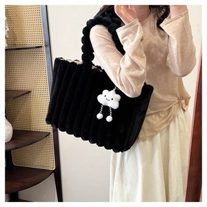 Detail of black plush tote bag with striped faux fur texture and cloud charm