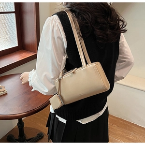 Vista dettagliata della borsa a spalla beige con mini pochette laterale abbinata