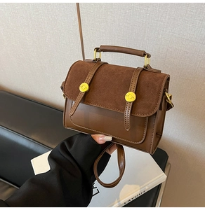 Detail of a brown vintage crossbody bag featuring suede textures and gold metal handles