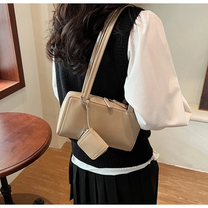 Borsa sottobraccio beige minimalista con mini portamonete coordinato indossata dal modello