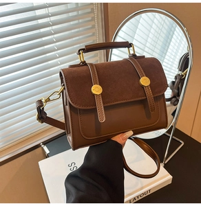 Detail of vintage brown shoulder bag with suede textures and golden metal accents