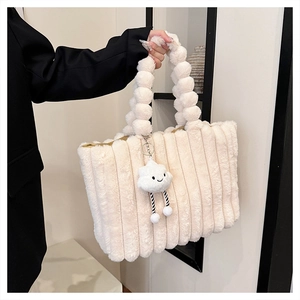 Detail of plush off-white tote bag with vertical stripes and sphere beaded handle