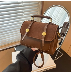 Detail of vintage brown crossbody bag with matte拼接 and gold hardware in sunlight
