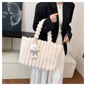 Detail of plush tote bag featuring vertical quilted texture and cloud pendant