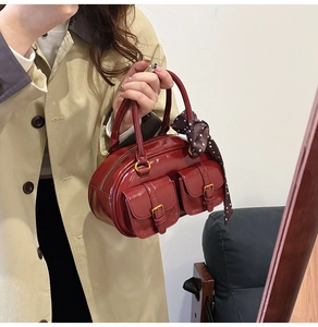 Detail of vintage burgundy boston bag with silk scarf and polished shiny finish