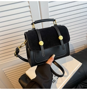 Detailed view of black vintage crossbody bag showing faux suede stitching and gold metal buckle