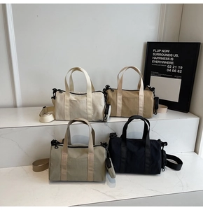 Quatre couleurs de sacs Boston en nylon sur des marches en marbre avec bretelles réglables