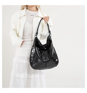 Vue détaillée du sac hobo en cuir verni noir avec boucles argentées et texture brillante