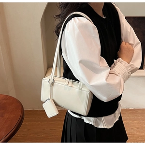 Dettaglio della borsa sottobraccio in pelle bianca con mini borsellino coordinato