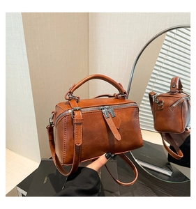 Detailed view of a vintage brown bucket bag with top handle and silver hardware