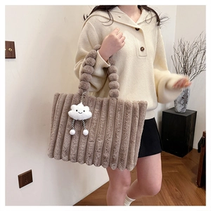 Brown faux fur tote bag with bubble handle and cloud pendant shown on beige sweater