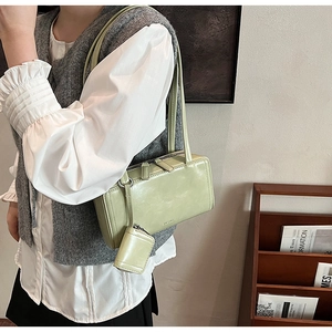 Borsa a tracolla verde salvia con mini pochette abbinata mostrata su una modella