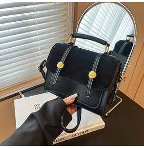 Detail of black crossbody bag featuring matte leather, suede flap and gold hardware