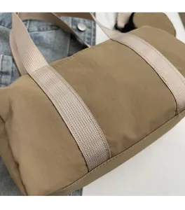 Détail du sac Boston kaki montrant le tissu doux texturé et les sangles tissées