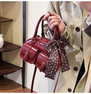 Detail of vintage red bowling bag with retro silk scarf and metallic buckle pockets