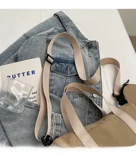 Gros plan sur la bandoulière réglable et le tissu en nylon kaki du sac besace