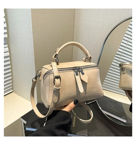 Detail of beige PU leather bowling bag showing double zippers and reinforced handles