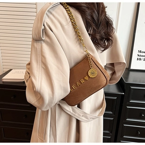 Brown suede crossbody bag with chunky gold chain strap and Lear metal heart logo detail