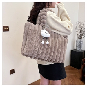 Detail view of large fuzzy tote bag with textured plush fabric and cloud charm