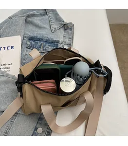 Sac polochon en nylon kaki avec fermeture éclair noire sur fond de veste en jean