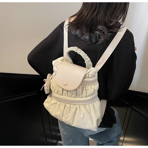 Detail view of the pleated nylon backpack with cloud-like handle and matching coin pouch