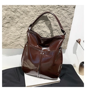 Gros plan sur le sac fourre-tout marron brillant avec rivets argentés et coutures