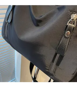 Detail aus schwarzem Nylongewebe mit Silber-Reißverschluss und Leder-Zipper-Zug