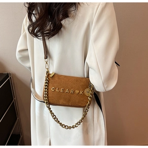 Macro detail of brown matte suede crossbody bag featuring gold metal CLEAR K letter logo