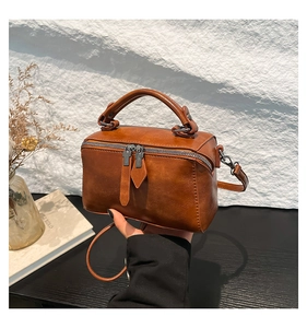 Detail shot of the retro brown bucket bag with smooth texture and sturdy top handle