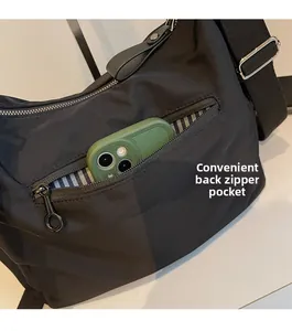 Detailansicht der Reißverschlusstasche an schwarzer Tasche mit gestreiftem Innenfutter