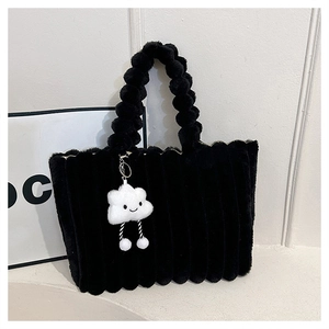 Detail of plush black tote bag featuring striped faux fur and a cloud charm