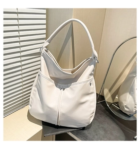 Gros plan du sac cabas en cuir PU crème avec poche incurvée et détails de rivets