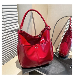 Vue détaillée du grand sac cabas en cuir verni rouge avec rivets et surpiqûres