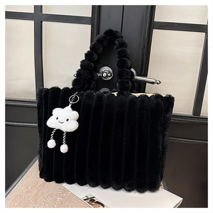 Detail of black faux fur tote bag with plush ball handle and white cloud charm
