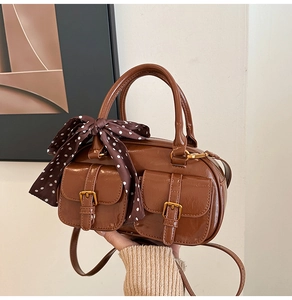Brown polished retro bowling bag with front pockets and silk scarf handle detail