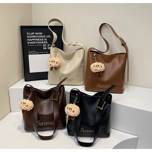 Detailed view of four leather bucket bags with Summer print and plush charms
