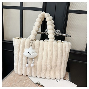 Close-up of cream plush tote bag with striped texture and beaded handle detail