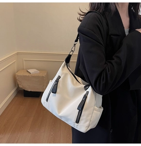 Details einer minimalistischen weißen Canvas-Tasche mit Reißverschlüssen und Gurt