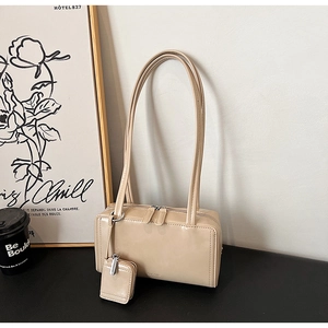 Dettaglio borsa a spalla beige lucida con doppia zip e un piccolo portamonete coordinato