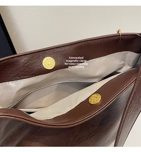 Detail of the hidden magnetic closure and herringbone lining inside the brown leather tote bag