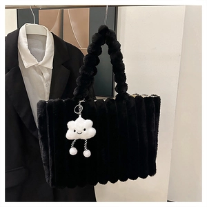 Detail of plush black tote bag with unique bubble handles and cute cloud pendant