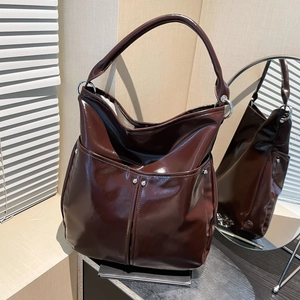 Détail du sac cabas marron foncé brillant avec boucles métalliques et doubles poches