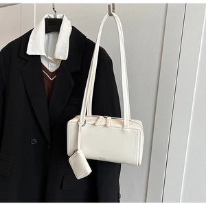 Dettaglio della borsa rettangolare bianco crema con cerniera argento e mini pochette