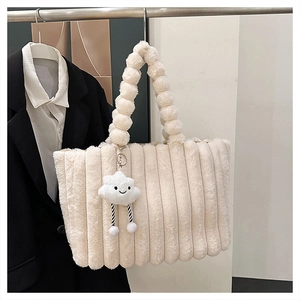 Close-up of plush off-white tote bag with textured stripes and cloud charm