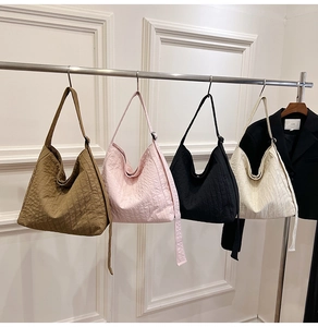 Quatre sacs hobo plissés en marron, rose, noir et crème présentés en détail
