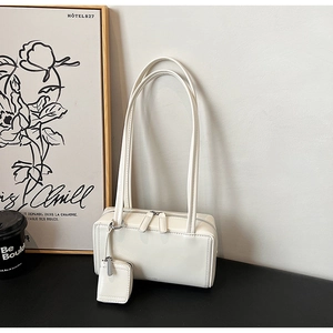 Borsa a spalla minimalista bianca in finta pelle con cerniere e mini ciondolo portamonete