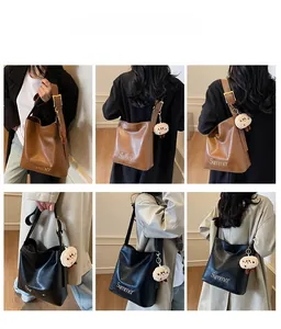 Detail of large leather tote bags with Summer print and plush charms in black and brown