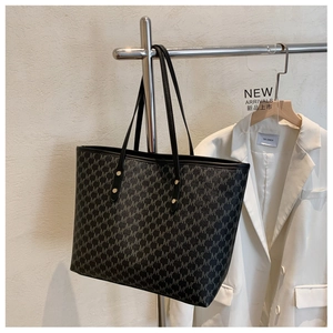 Dettaglio della classica borsa tote nera con motivo logo M grigio e borchie d'oro
