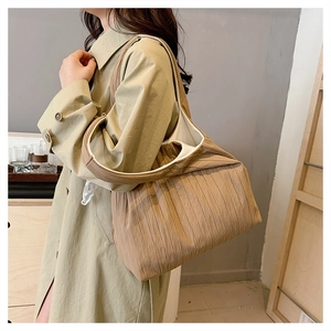 Detail of khaki pleated tote bag showing large capacity and soft fabric texture on shoulder