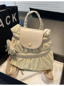 Chic pleated nylon backpack in cream yellow featuring a matching mini round coin purse charm